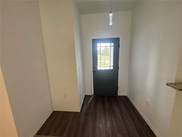 a view of a room with wooden floor a ceiling fan and a window