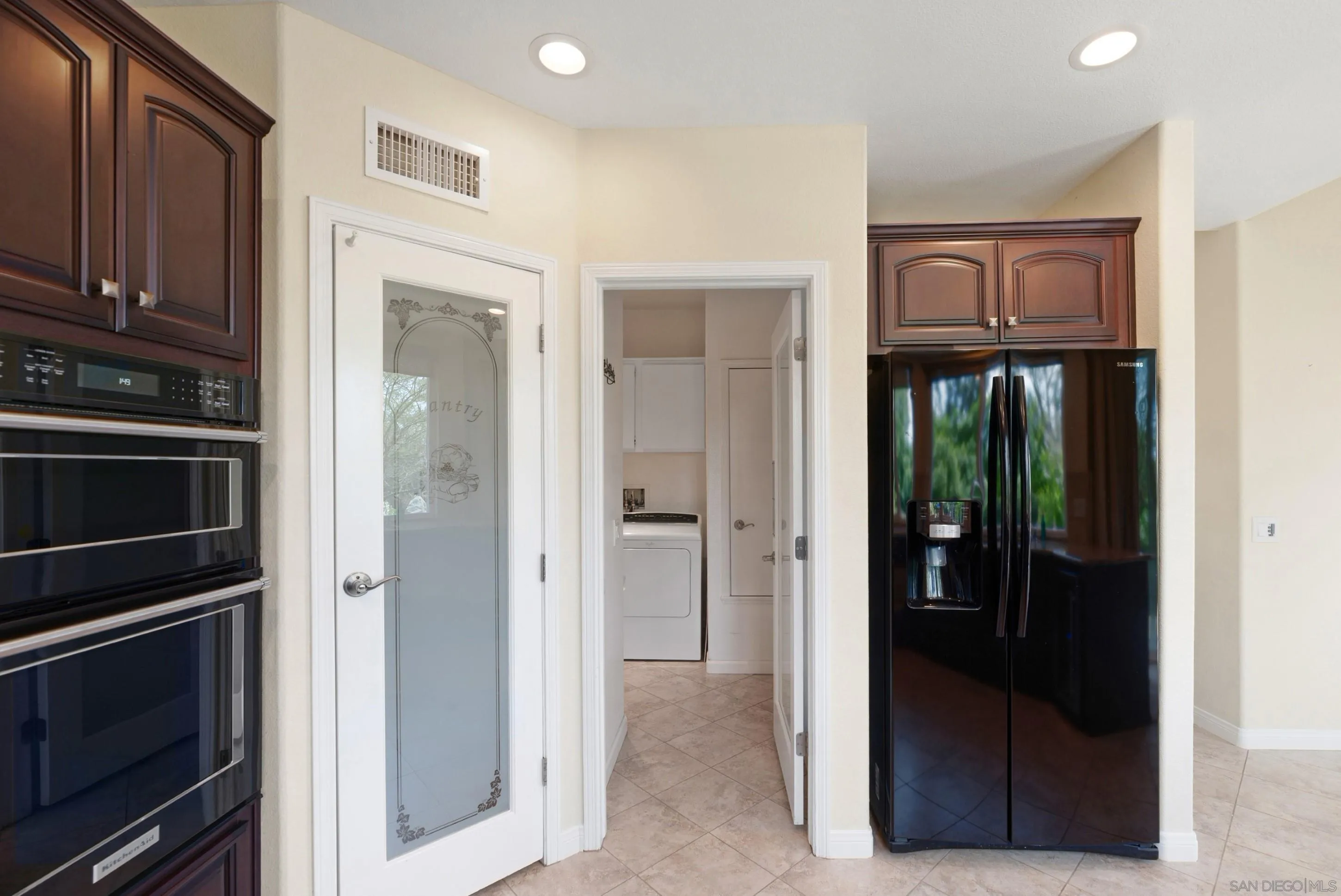 14505 Wildgrove Road Poway, CA 92064 - Photo 6 of 55 a view of kitchen with refrigerator cabinets and front door