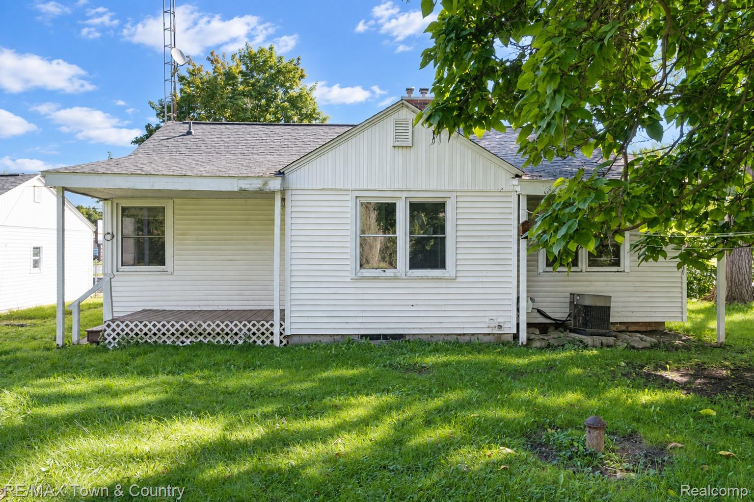 300 Elms Road Flushing, MI 48433 - Photo 23 of 26 White horizontal siding exterior with a covered porch and lattice skirting