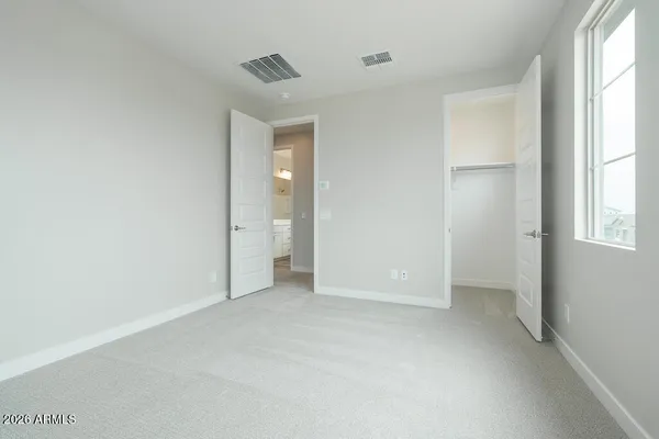 an empty room with windows and closet