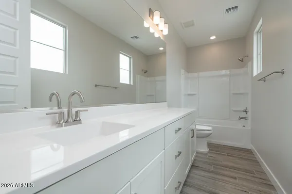 a bathroom with a double vanity sink a toilet and a mirror
