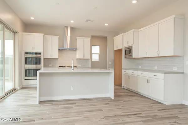 a large kitchen with cabinets and wooden floor