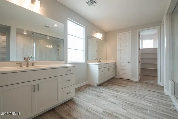 a bathroom with a double vanity sink a mirror and a bathtub