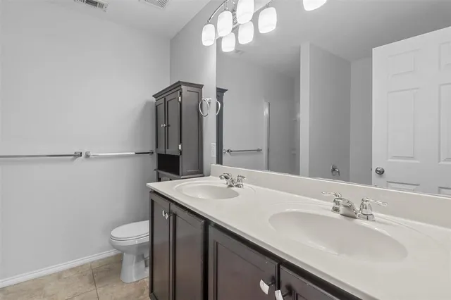a bathroom with a sink a toilet and a mirror
