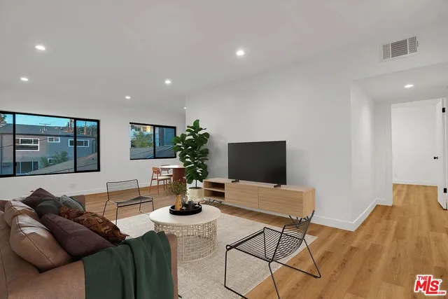 a living room with furniture a flat screen tv and a large window