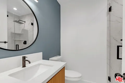 a bathroom with a sink toilet and mirror