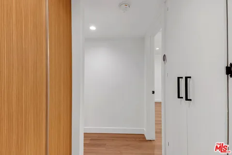 a view of a big room with wooden floor and windows