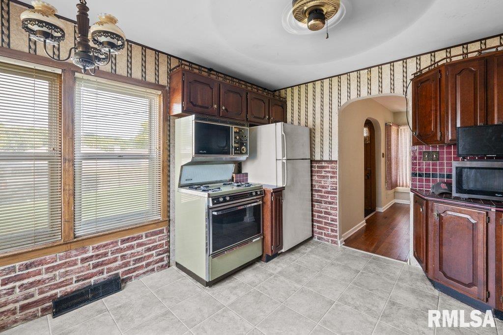 4234 9th Street Rock Island, IL 61201 - Photo 7 of 22 a kitchen with stainless steel appliances granite countertop a stove a refrigerator and a sink