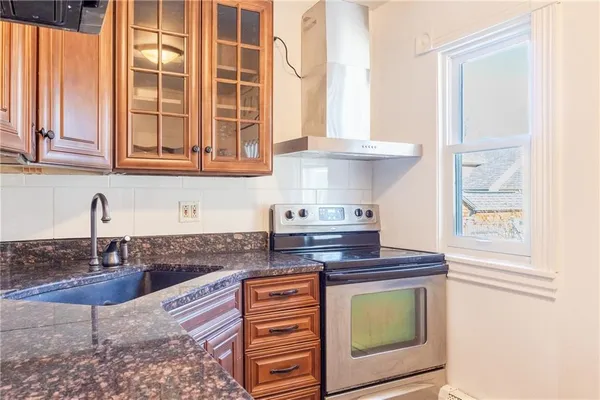a kitchen with stainless steel appliances granite countertop a stove a sink and a microwave