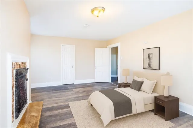 a spacious bedroom with a bed and painting on the wall