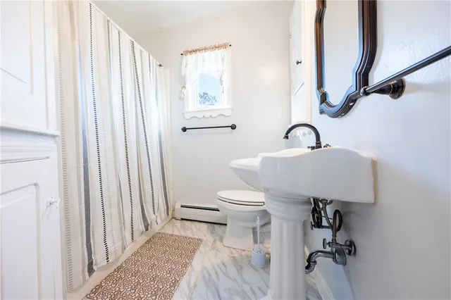 a bathroom with a sink toilet and a window