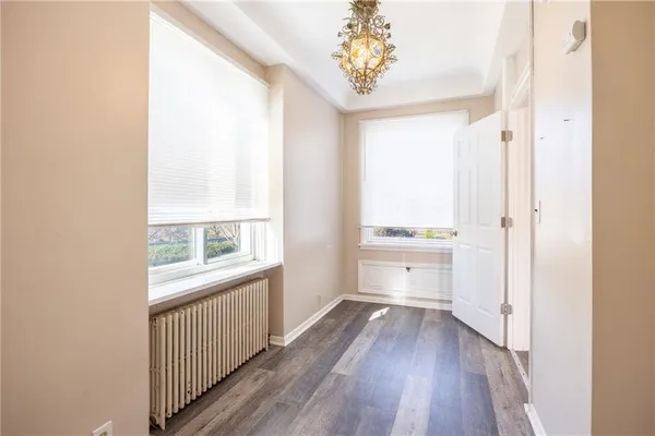 a view of a hallway with wooden floor and a window