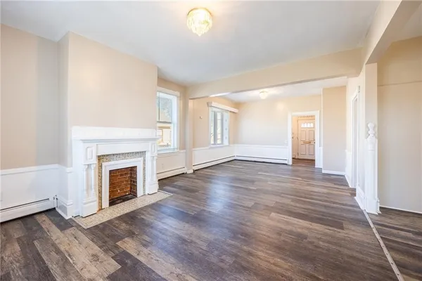 a view of a livingroom with wooden floor and a fireplace