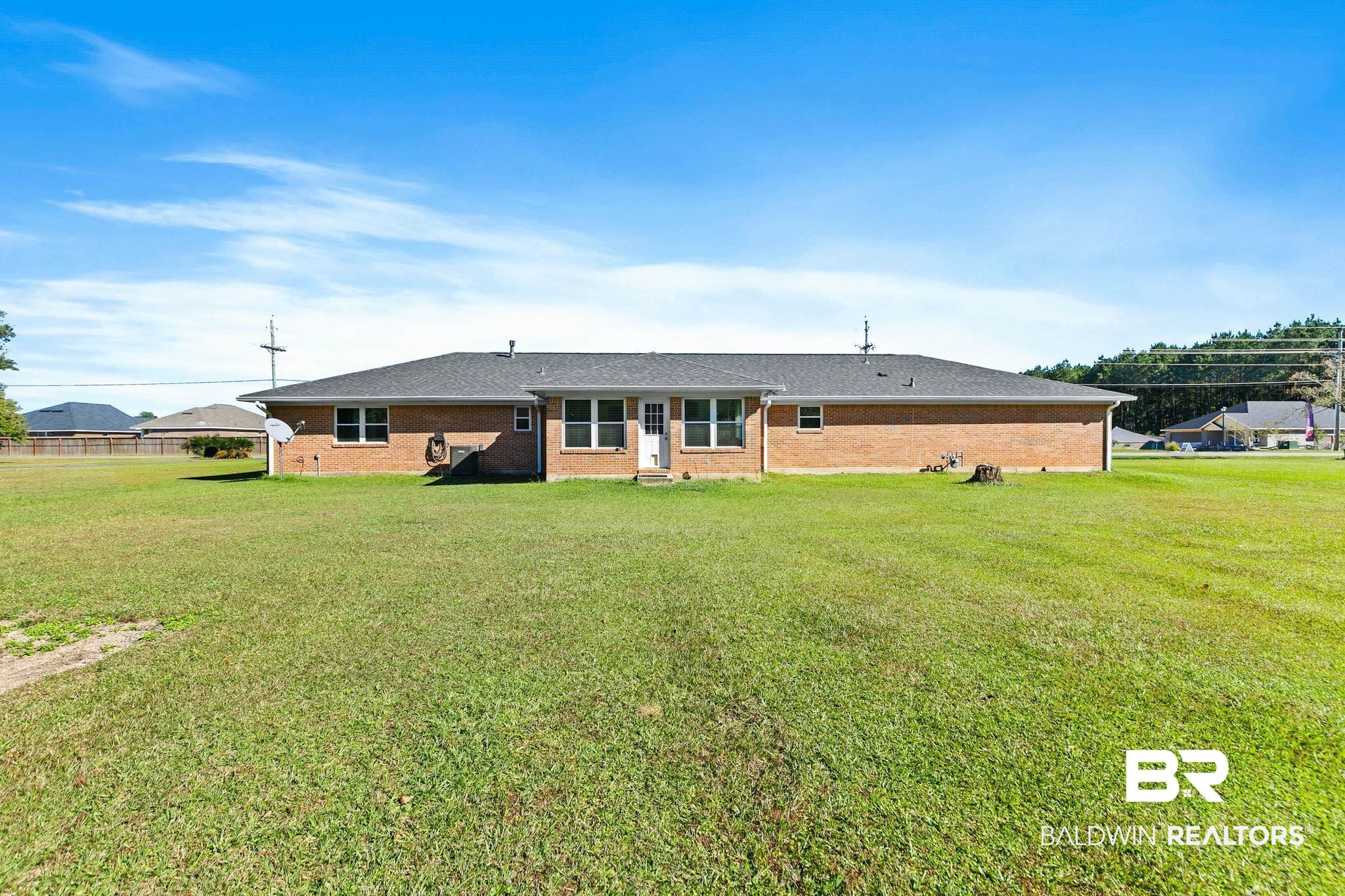 1510 South Juniper Street Foley, AL 36535 - Photo 28 of 36 Back of house with a yard, brick siding, and roof with shingles