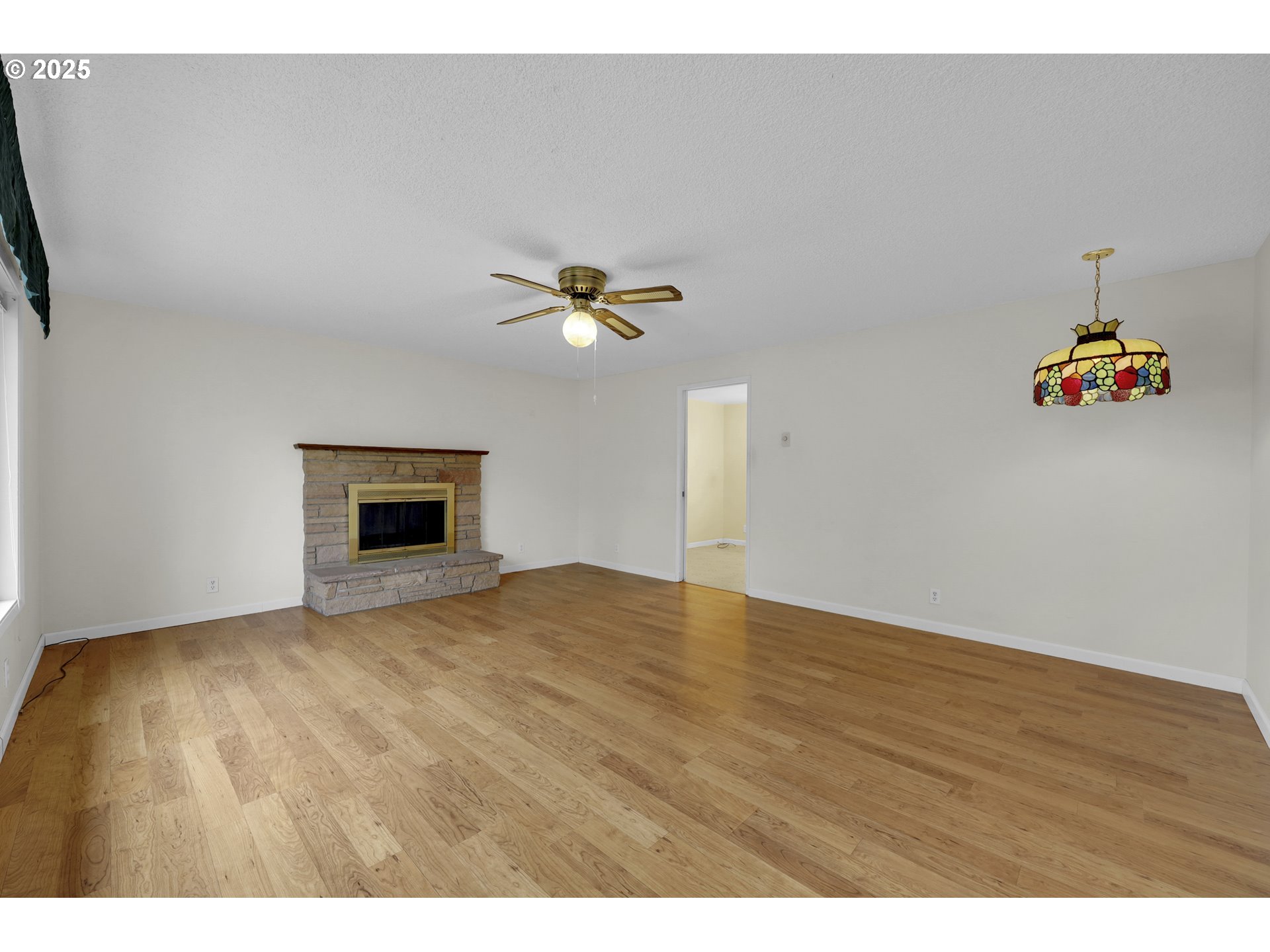 2315 19th Street Springfield, OR 97477 - Photo 4 of 30 a view of empty room with wooden floor and fireplace