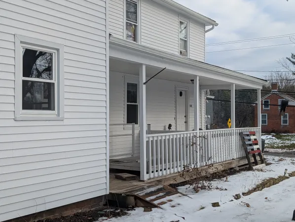 a view of a house with a small yard and wooden fence