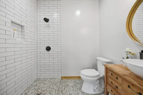 a bathroom with a granite countertop toilet a sink and a mirror
