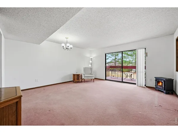 a view of an empty room with a fireplace and a large window