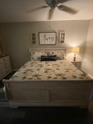 a bedroom with a bed and painting on the wall
