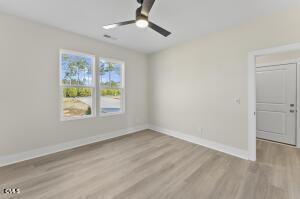 2760 River Meadow Spring Hope, NC 27882 - Photo 22 of 42 an empty room with wooden floor chandelier fan and windows