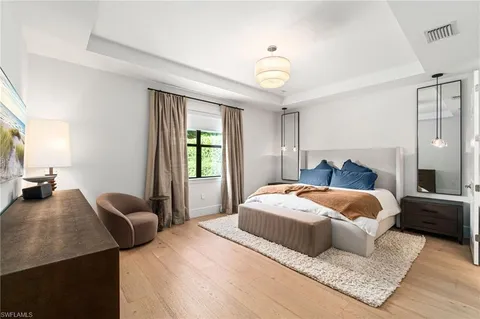 a bedroom with a large bed and a chandelier