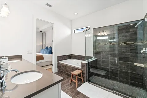a bathroom with a granite countertop sink a toilet a mirror and shower