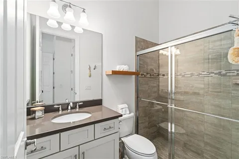 a bathroom with a sink toilet a mirror and shower