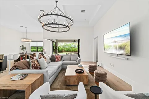 a living room with furniture a window and a chandelier