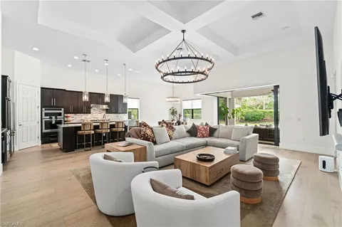 a living room with furniture kitchen and a chandelier