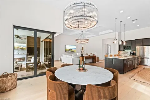 a kitchen with stainless steel appliances a table and chairs in it