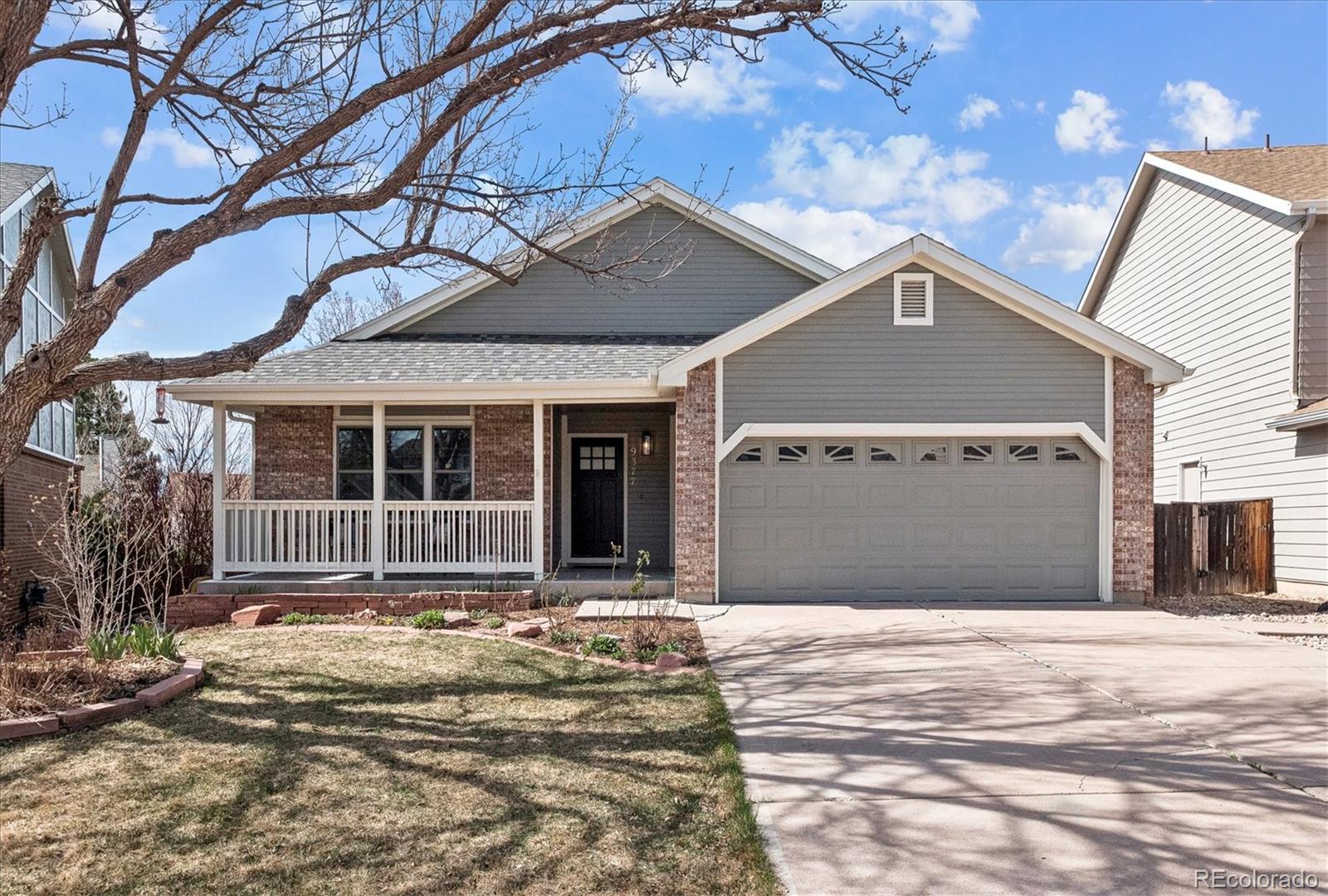 9377 Newport Lane Highlands Ranch, CO 80130 - Photo 1 of 26 a front view of a house with a yard and garage