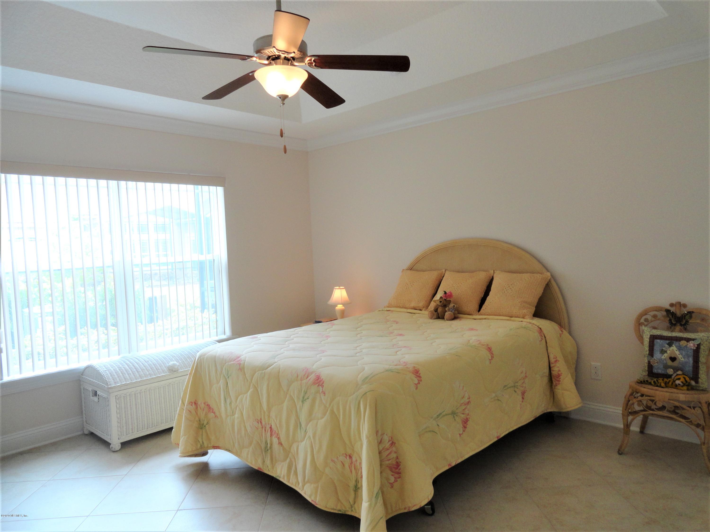 33 Utina Way St. Augustine, FL 32084 - Photo 21 of 30 a bedroom with a bed and a chandelier