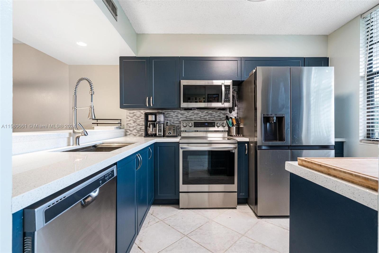 a kitchen with stainless steel appliances a stove sink microwave and refrigerator