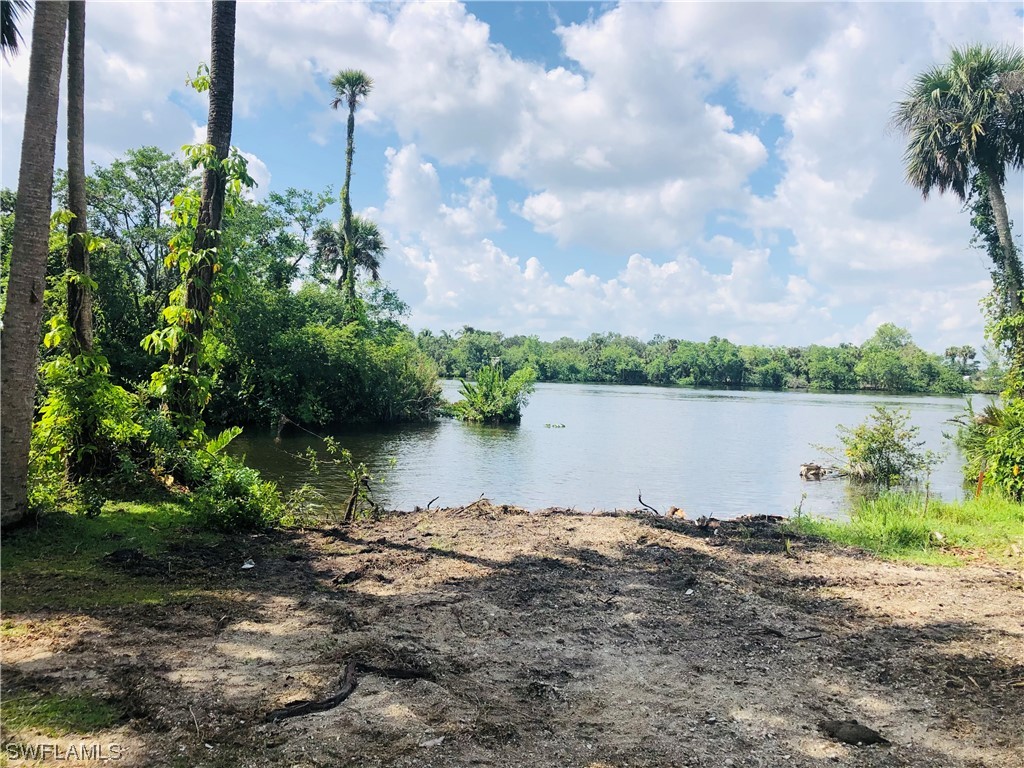 17720 Caloosa Road Alva, FL 33920 - Photo 1 of 7 a view of a lake with houses in the background