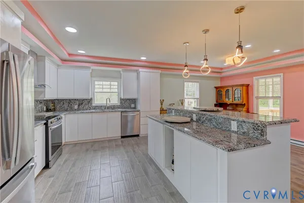 a kitchen with stainless steel appliances granite countertop a stove oven and a refrigerator