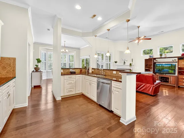 a large white kitchen with lots of counter top space and stainless steel appliances