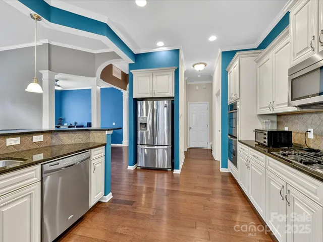 a kitchen with stainless steel appliances granite countertop a refrigerator a sink and a stove