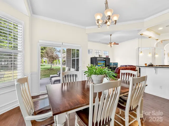 a view of a dining room with furniture a chandelier and wooden floor