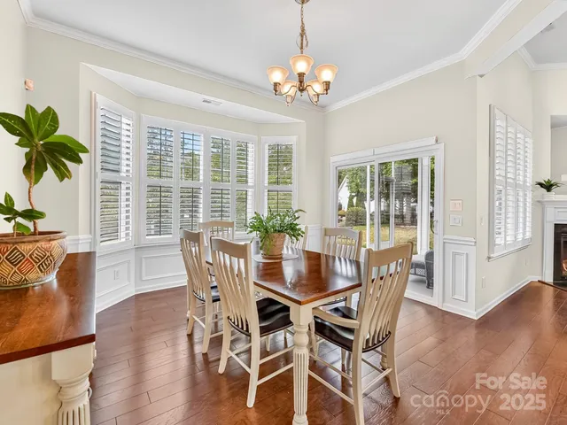 a dining room with furniture potted plants and wooden floor