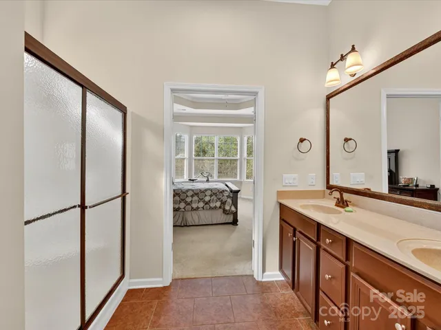 a en suite bathroom with a granite countertop sink and a large mirror