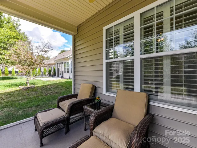 a view of a patio with couches chairs and wooden fence