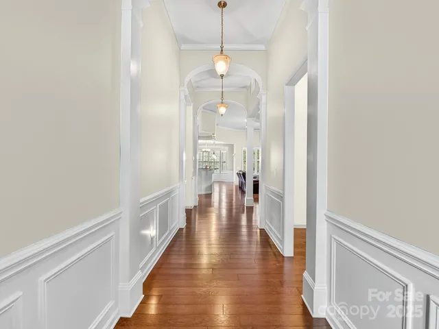 a view of a hallway with wooden floor and staircase