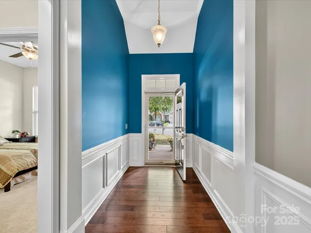 a view of a hallway with wooden floor and staircase