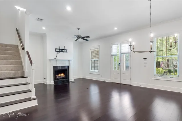 a view of a livingroom with wooden floor fireplace and windows