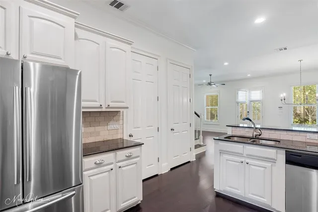 a kitchen with white cabinets and stainless steel appliances