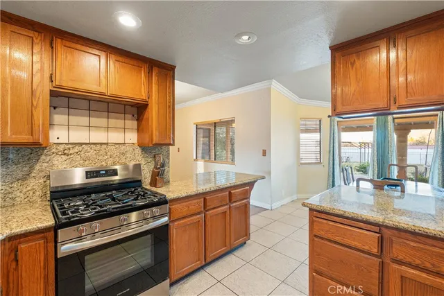 a kitchen with stainless steel appliances granite countertop a refrigerator a stove and a sink