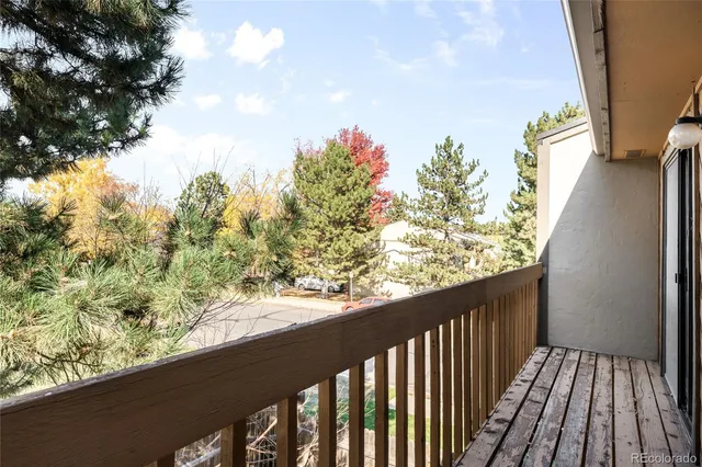 a backyard of a house with large trees and wooden fence