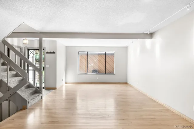 a view of empty room with wooden floor and entryway