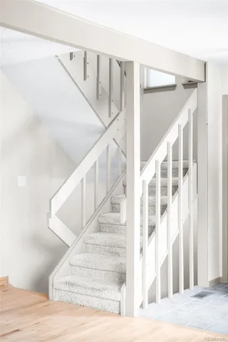 a view of empty room with wooden floor and stairs