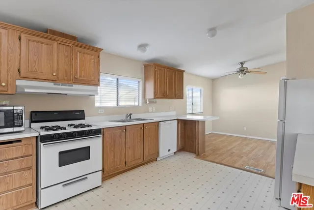 a kitchen with granite countertop white cabinets and white appliances